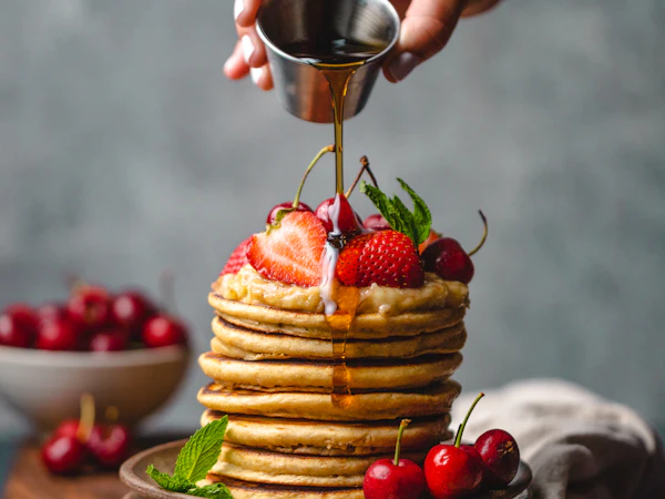 Sirope cayendo sobre una pila de pancakes